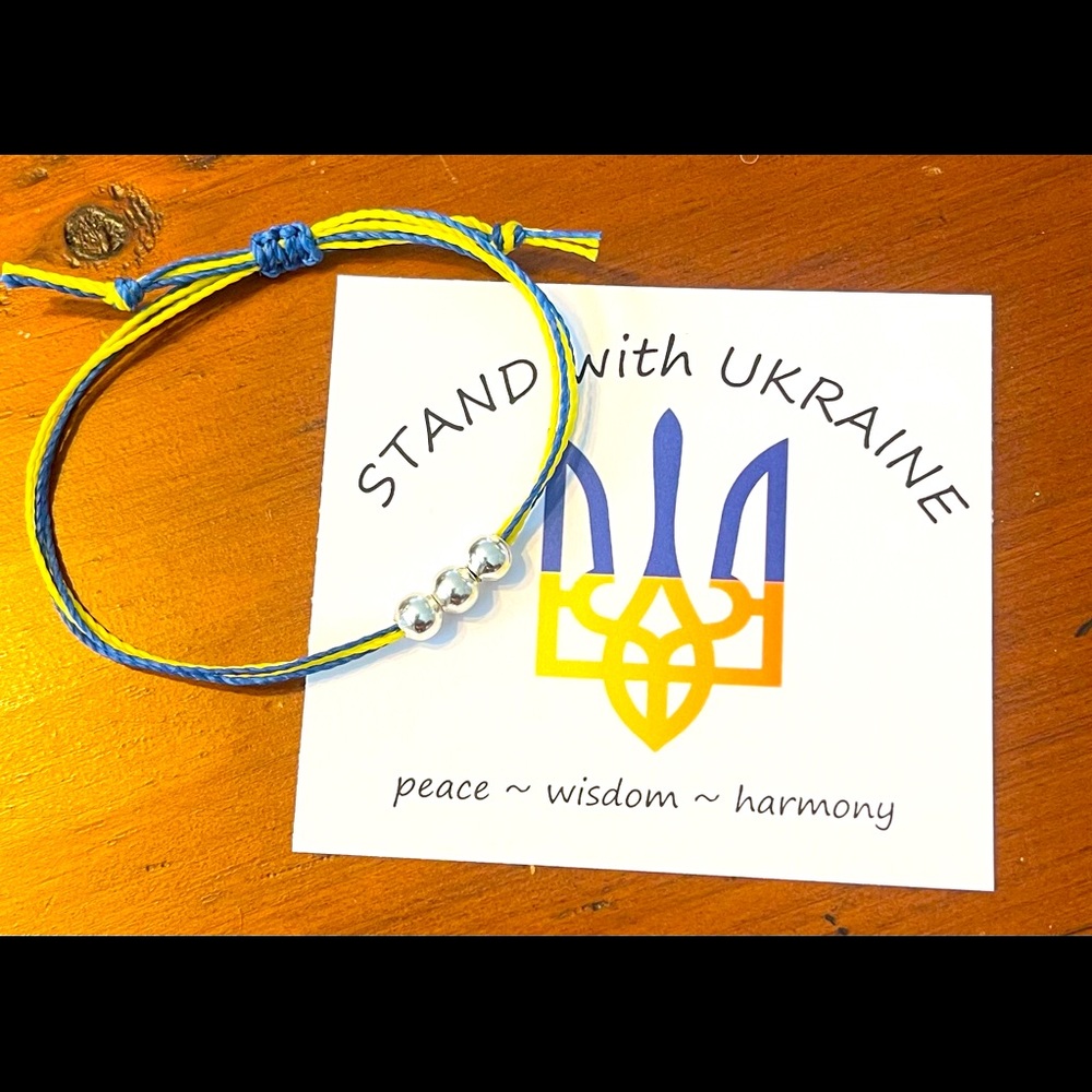 “STAND with Ukraine” string bracelet with 3 silver toned beads. Slide knot